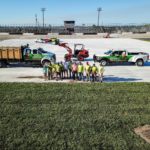 A group of people standing in front of trucks.