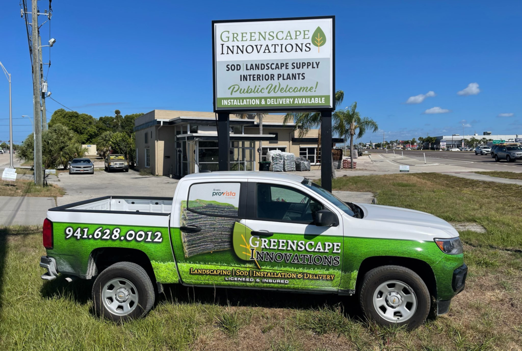 A truck parked in front of a sign for landscape innovations.