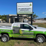 A truck parked in front of a sign for landscape innovations.