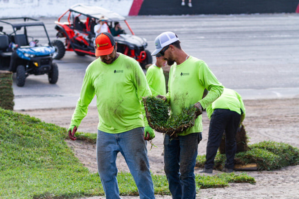 A group of men in green shirts and hats.