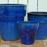 Three blue pots are sitting on the ground.