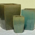 Three different sized pots are sitting on the floor.